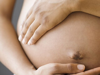 жена държи бременния си стомах