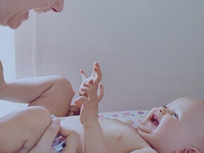 усмихната майка си играе с бебе усмихната майка си играе с бебе